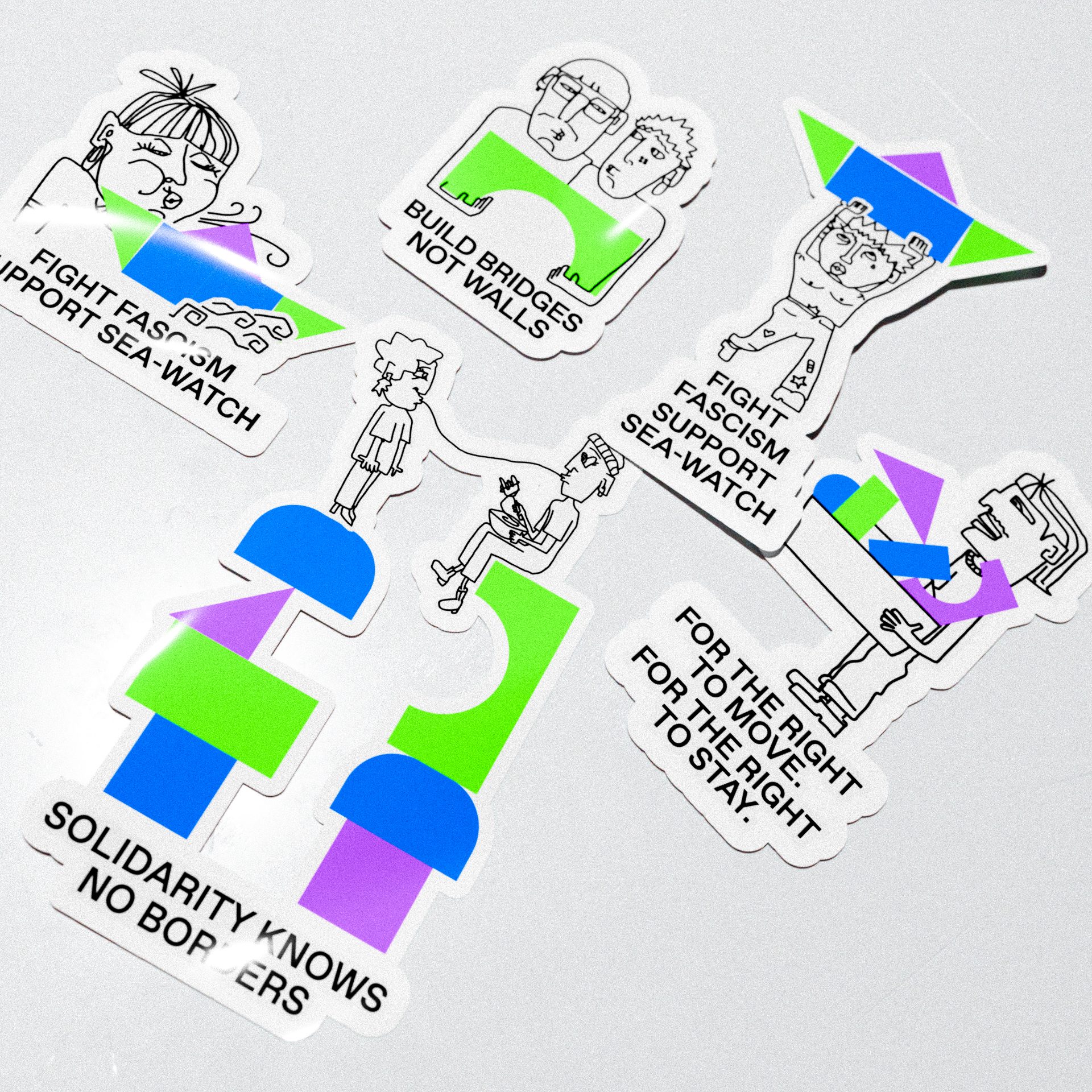 Mehrere Sticker für Sea-Watch auf einer grauen Fläche