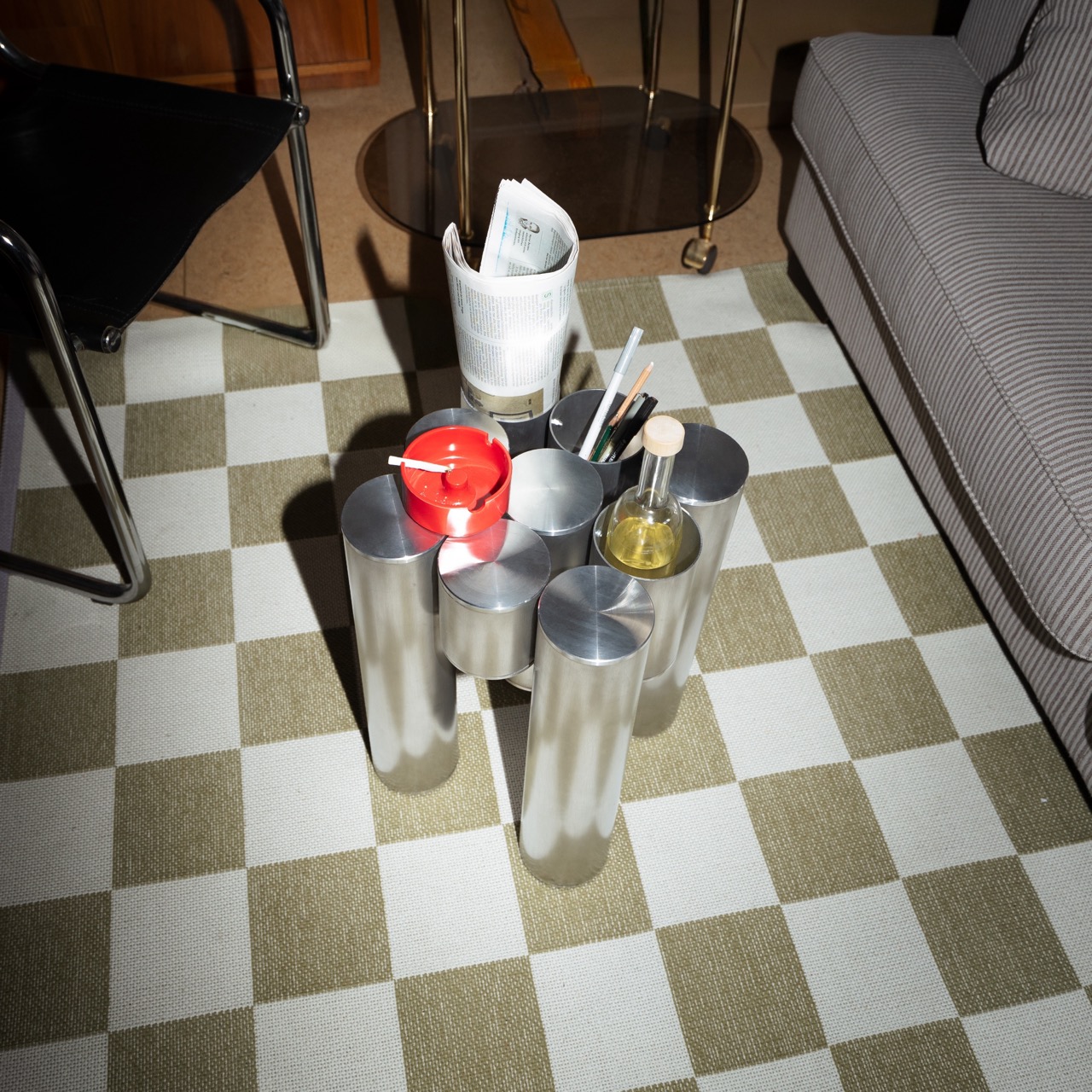 Tube Table: Beistelltisch aus gebürsteten Aluminiumrohren auf kariertem Teppich