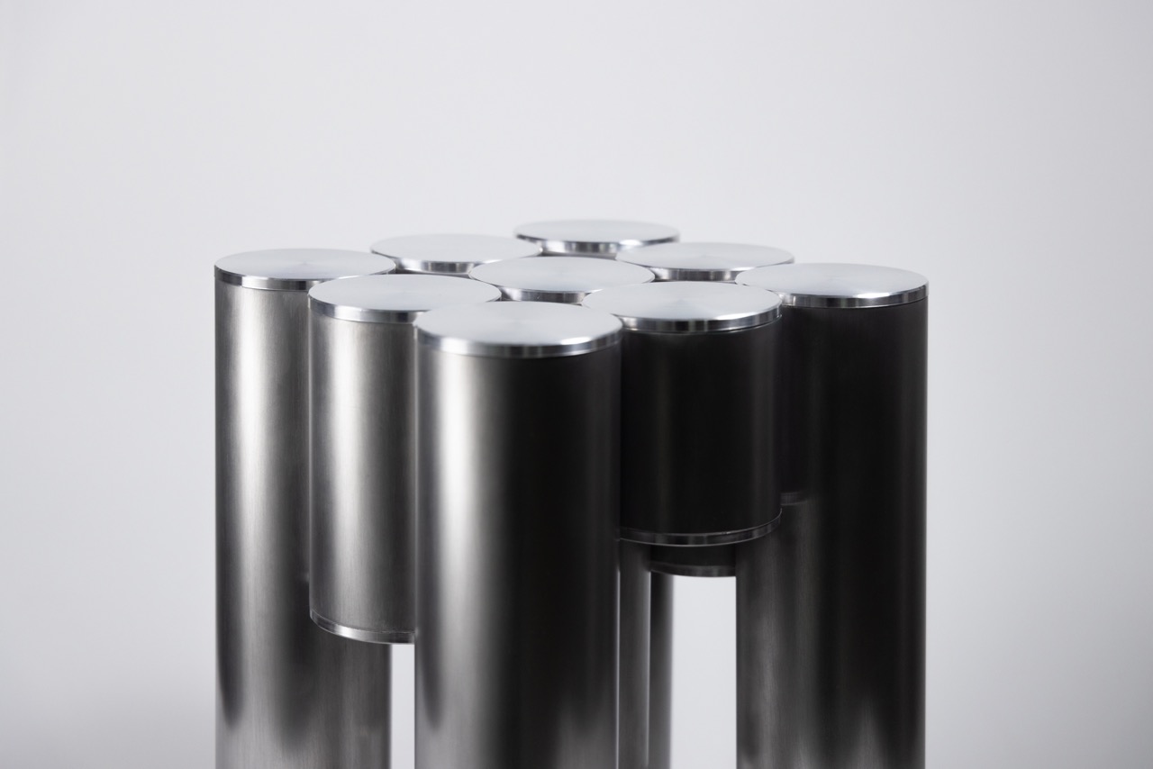 Tube Table: Aluminiumrohre unterschiedlicher Höhe vor grauem Hintergrund