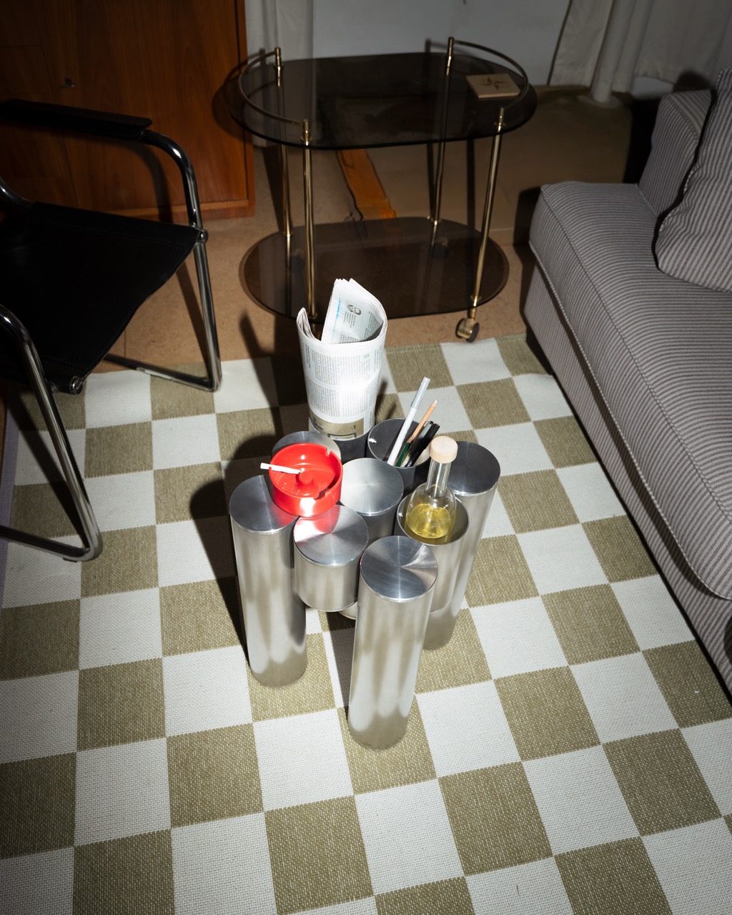 Tube Table mit Alltagsgegenständen auf kariertem Teppich