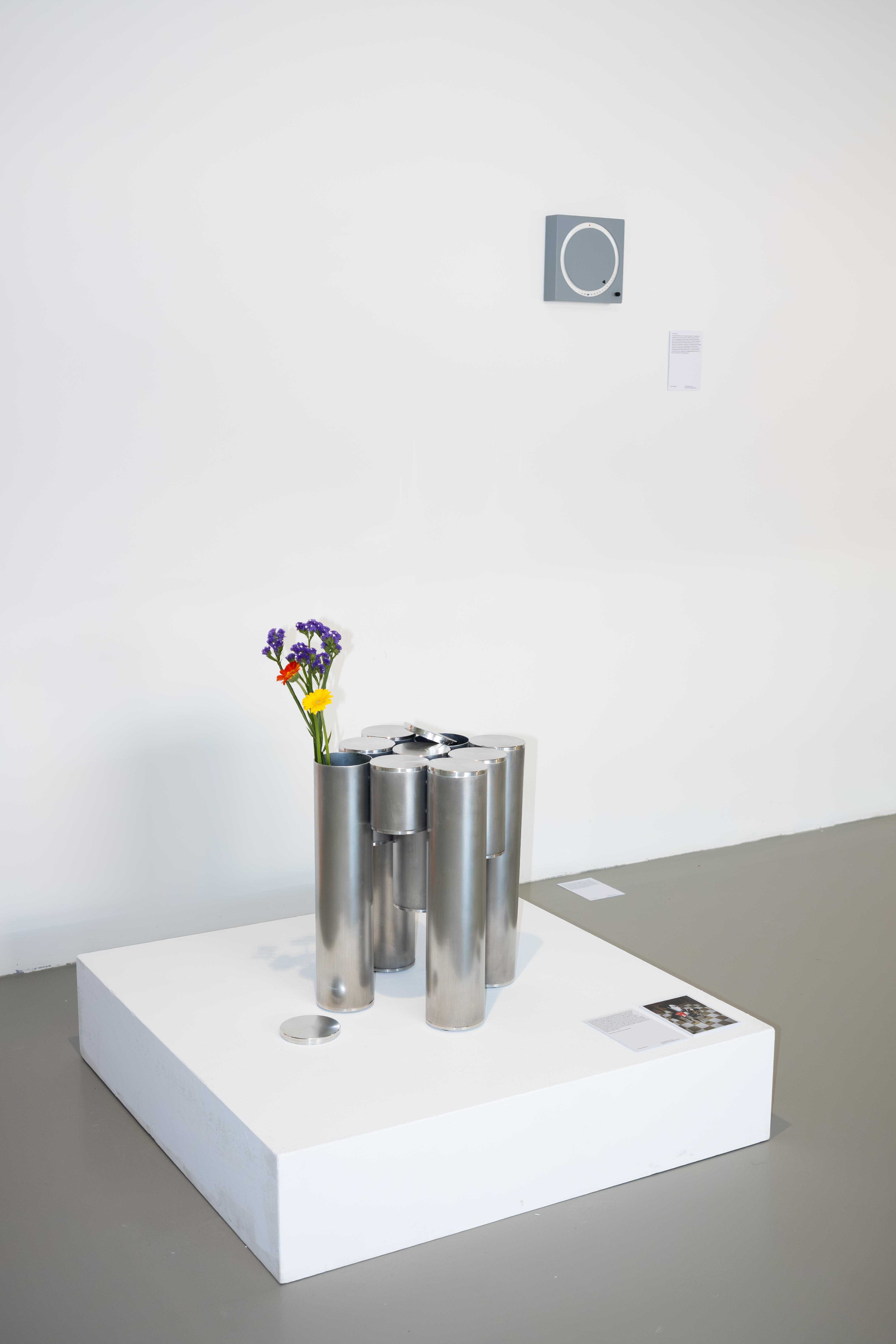 Ausstellungsansicht mit der Uhr an der Wand und dem Tube Table auf einem Sockel